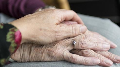 junge und alte hände trost spenden beim Trauergespräch